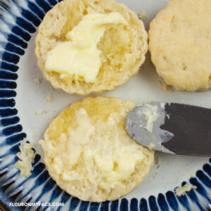 homemade biscuits cut open with butter spread on