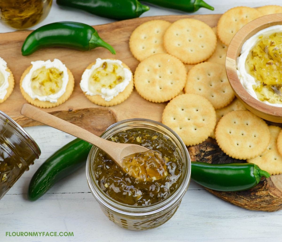 A opened jar of Jalapeno Jelly served with cream cheese and crackers.