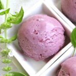 Bright purple homemade blackberry and lemon basil gelato in a white serving dish.
