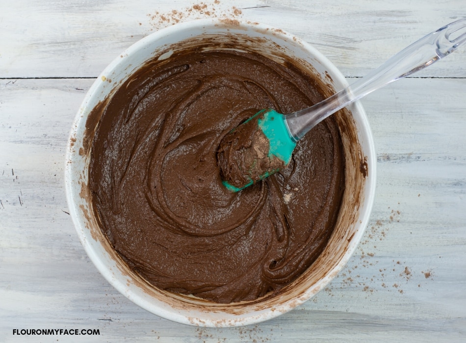 Mixing Nutella Brownies batter in a glass bowl