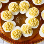Tangy Deviled Eggs on a brown glass holiday Deviled Eggs plate