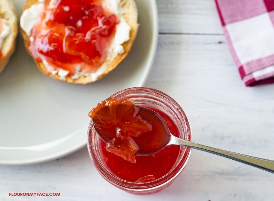 overhead photo of a spoonful of jam resting on top of an open jar of Carambola Strawberry Jam