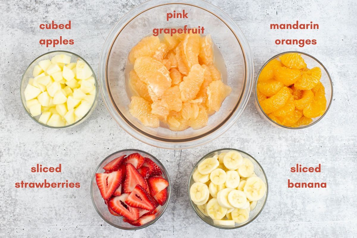5 types of fruit in individual bowls used to make citrus fruit salad.