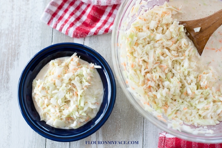 Homemade Coleslaw recipe in a blue Fiestaware bowl with a red and white cloth napkin.