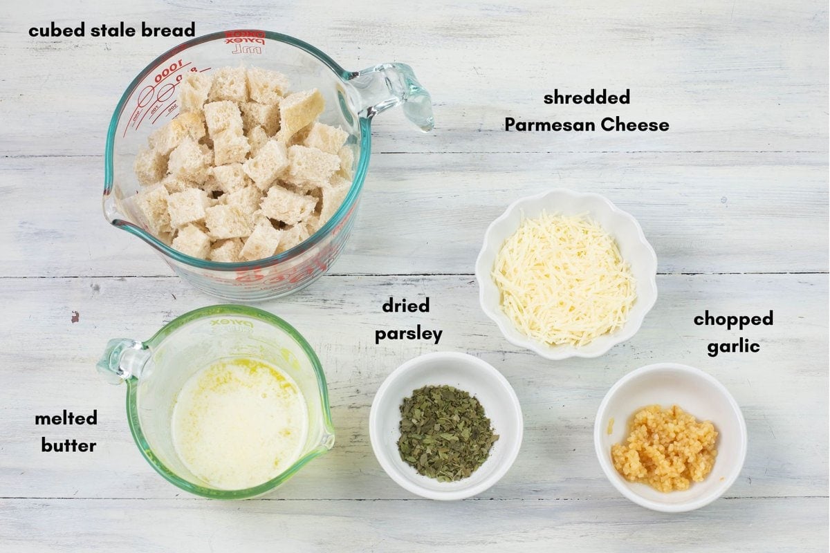 Homemade crouton ingredients in individual bowls and glass measuring cups.