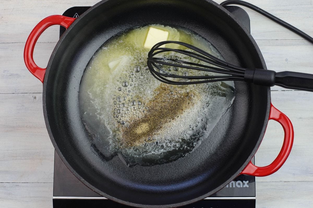 Melting butter in a skillet to make alfredo sauce.