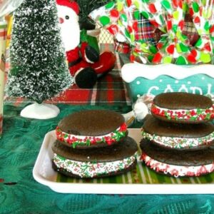 A decorative plate with a stack of chocolate peppermint whoopie pies.