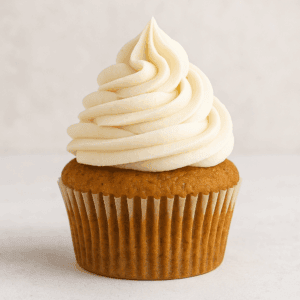 Close up of a pumpkin pie spice cupcake with a swirl of buttercream frosting.