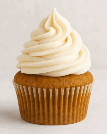 Close up of a pumpkin pie spice cupcake with a swirl of buttercream frosting.