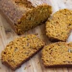 Sliced carrot cake bread on a wooden cutting board.