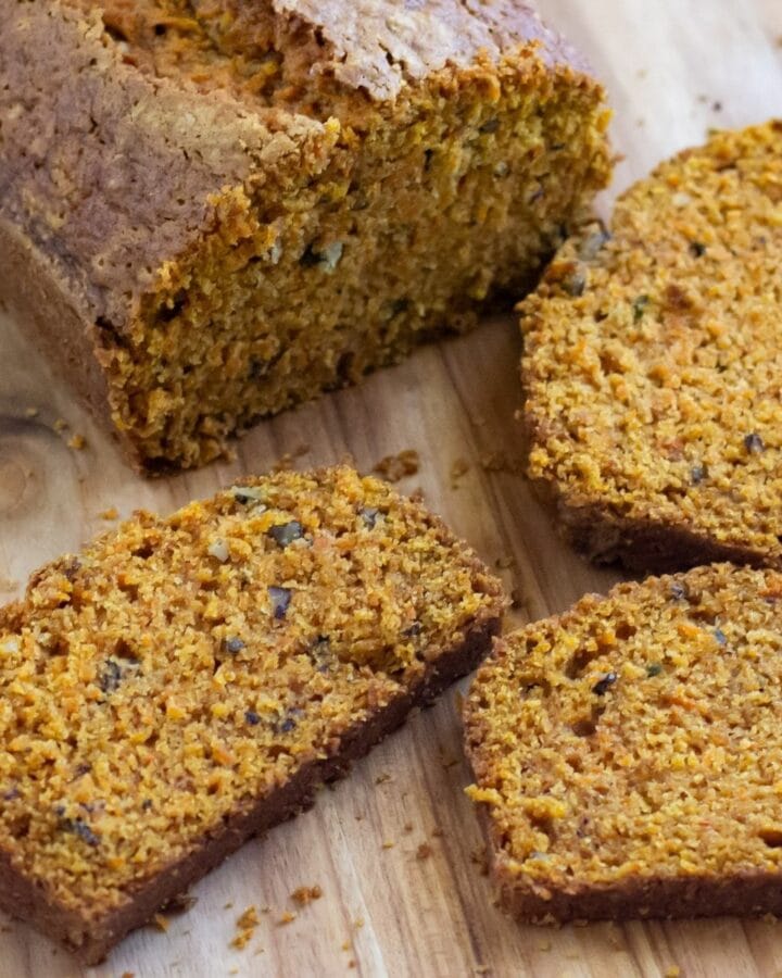 Sliced carrot cake bread on a wooden cutting board.