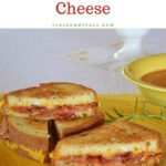 Rosemary Bacon Tomato Grilled Cheese Sandwich stacked on a yellow plate served with tomato soup