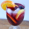 a wine glass filled with Sangria and fruit