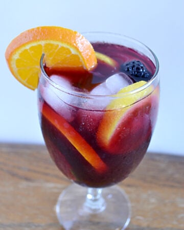 a wine glass filled with Sangria and fruit