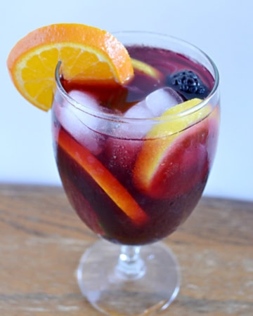 a wine glass filled with Sangria and fruit