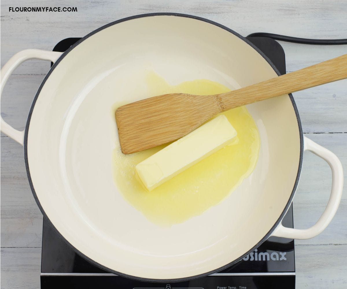 Melting a stick of butter in an enamel cast iron skillet.