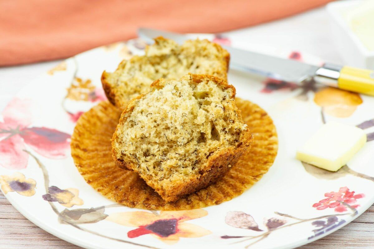 A muffin split in half on a plate showing how fluffy and moist the center is.