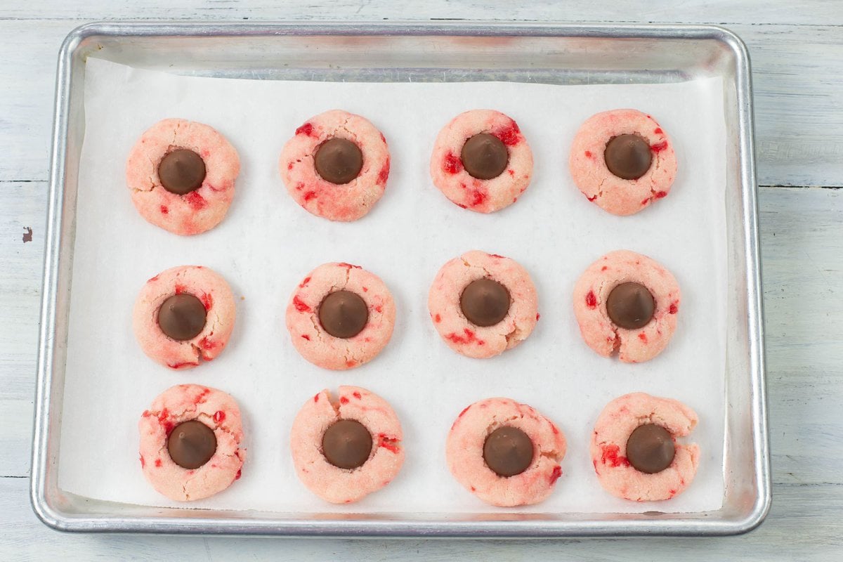 Fresh baked and still hot cherry blossom cookies with a Hersey Kiss pushed into the top. 