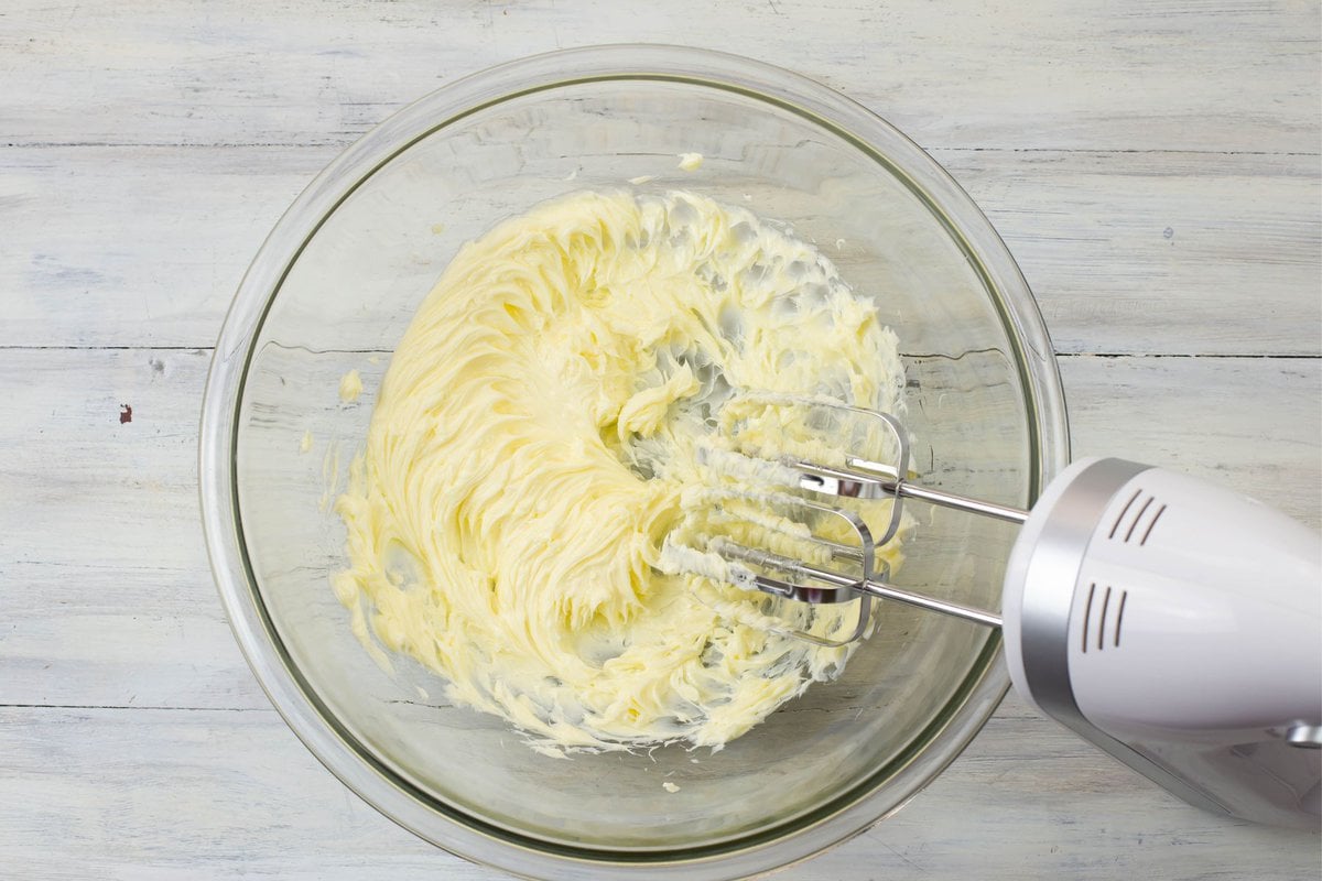Beaten butter in a mixing bowl.