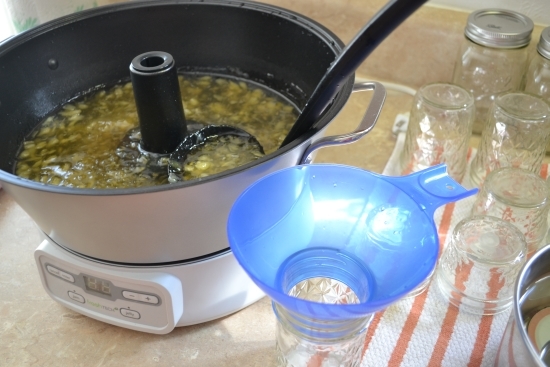 Filling the canning jars using a ladle.