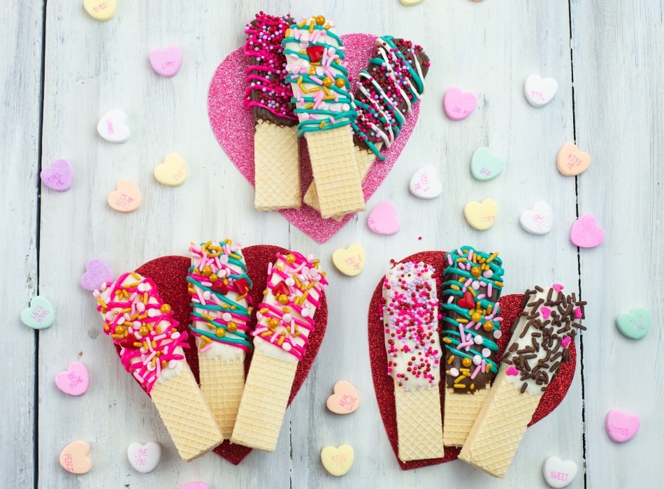 Decorated wafer cookies on pink hearts.