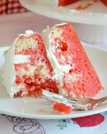 A slice of Strawberry poke cake on a dessert plate.