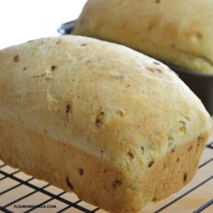 A loaf of homemade stuffing bread on a cooling rack.