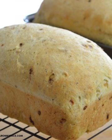 A loaf of homemade stuffing bread on a cooling rack.