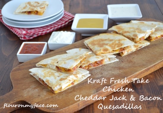 Chicken Cheddar Jack & Bacon Quesadillas served with dipping sauces on a wooden serving board.