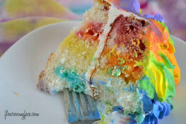 A colorful slice of Rainbow Jello Poke Cake via flouronmyface.com