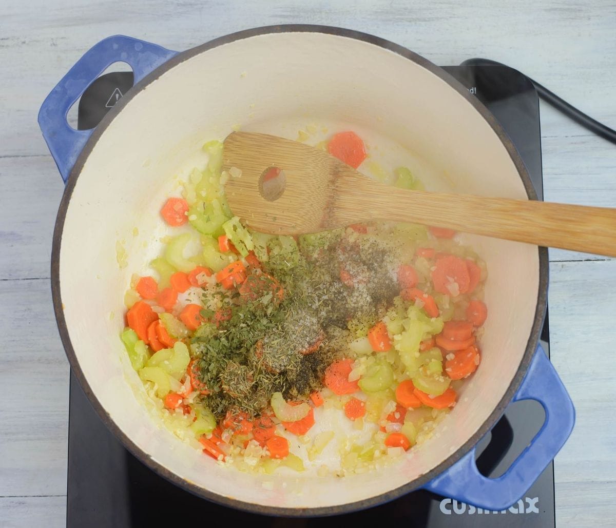 Adding seasonings to soup vegetables in the pot.