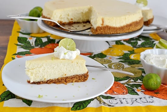 a Key Lime Cheesecake with a slice cut out and served on a dessert plate.