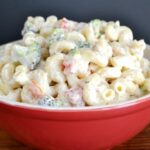 A red bowl filled with buttermilk ranch pasta salad.