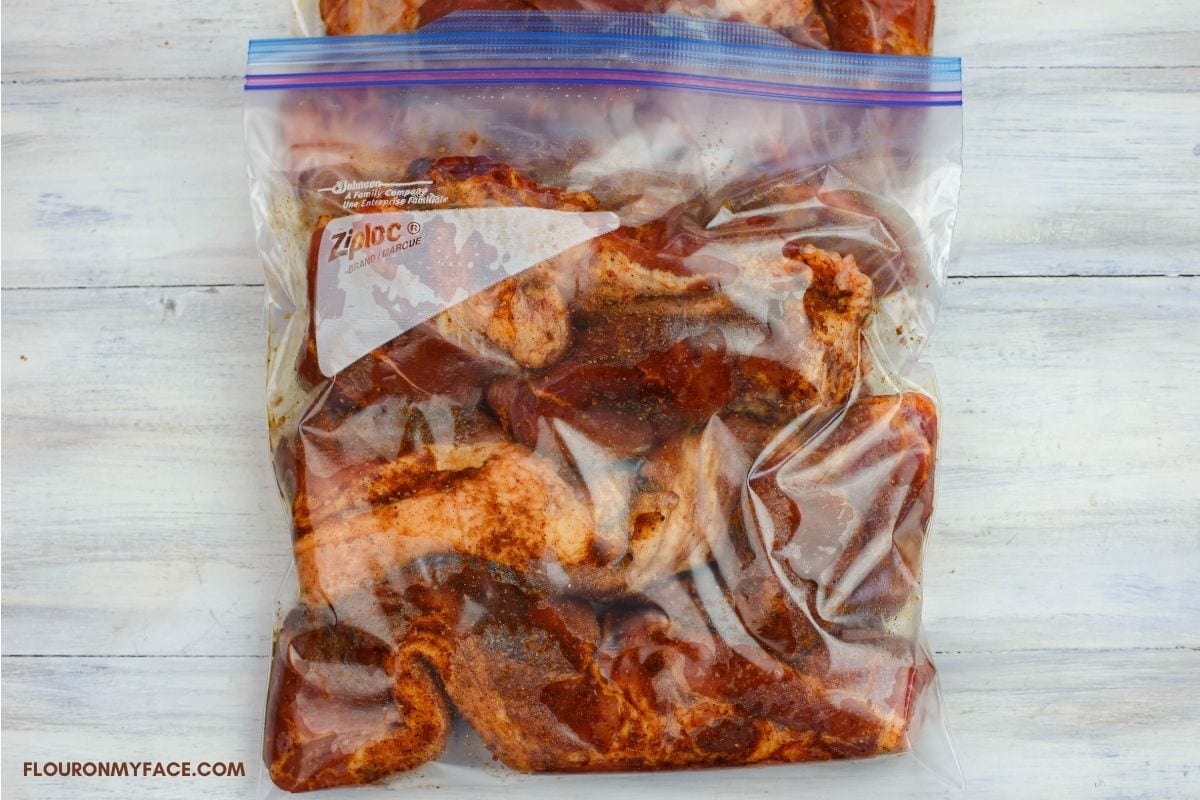 Seasoned boneless country style ribs in a plastic bag.