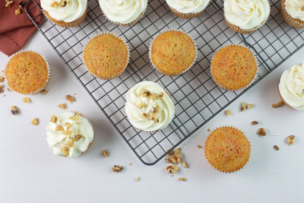 Frosted and unfrosted cupcakes on a wire rack.