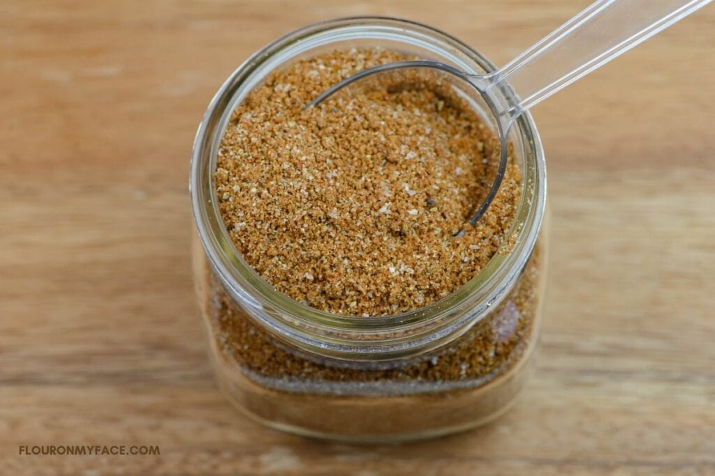 Pulled Pork Rub in a mason jar with a plastic scoop.