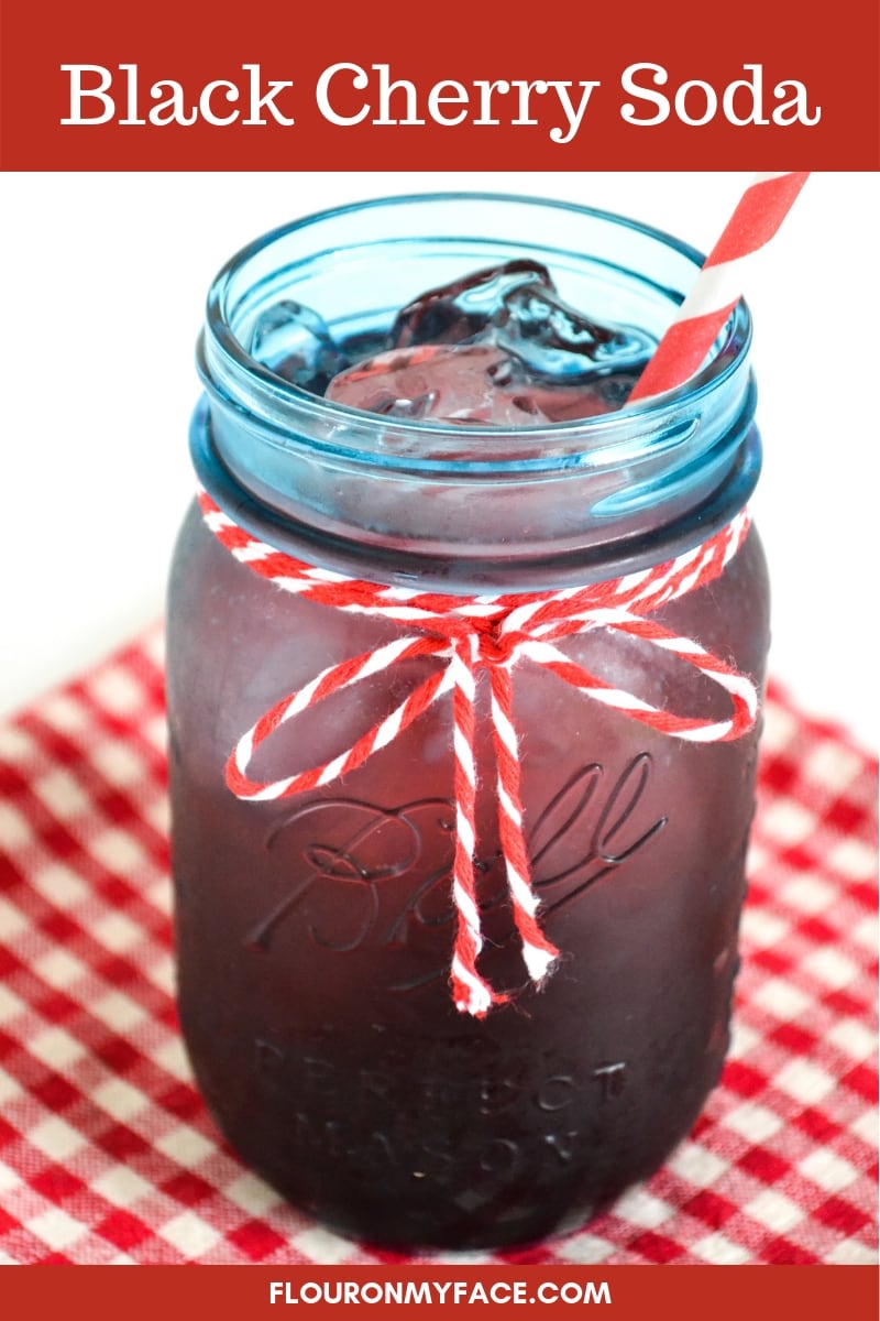 Blue vintage mason jar filled with homemade black cherry soda