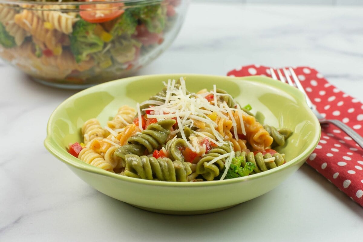 A serving of 30 minute Italian Pasta Salad recipe in a small bowl with the serving bowl in the background.