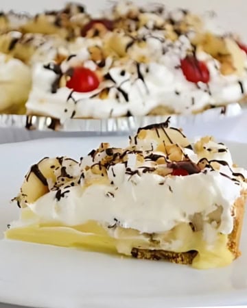 A slice of no bake Banana Split Pie on a plate with the pie in background.