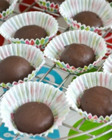 Homemade chocolate covered raspberry jellies in white paper cups.