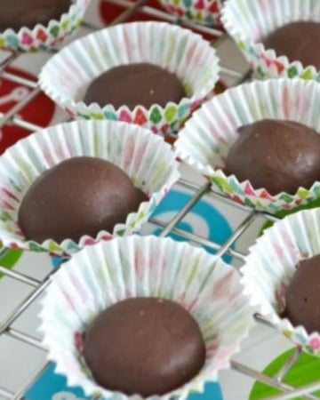 Homemade chocolate covered raspberry jellies in white paper cups.