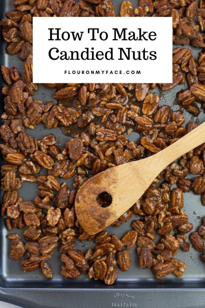 Sugar coated pecans are spread over a baking sheet before baking and drying when making candied nuts for Christmas
