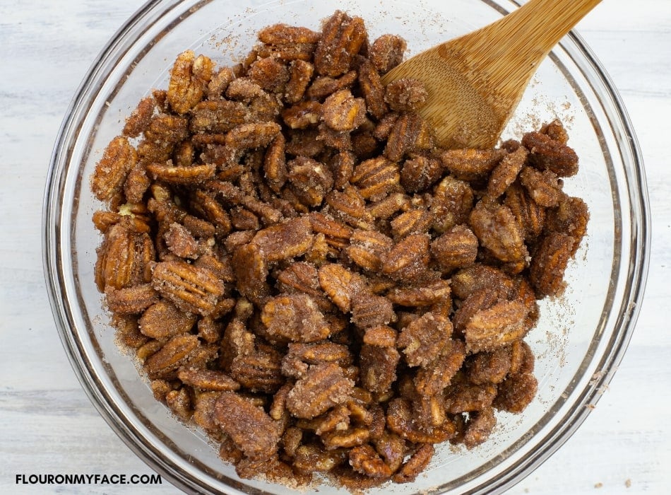 Step by step making candied pecans. Coating the pecans with sugar, cinnamon and vanilla