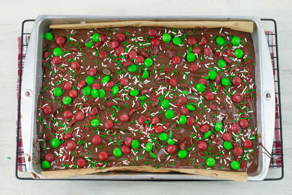 M&M Christmas Sugar Cookie Bars decorated with red and green M&M's and holiday sprinkles.