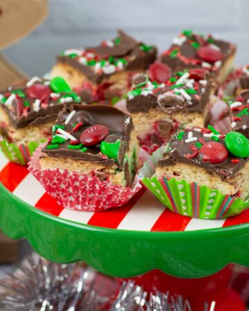Red and green M&M Sugar Cookie Bars on a holiday cake stand.