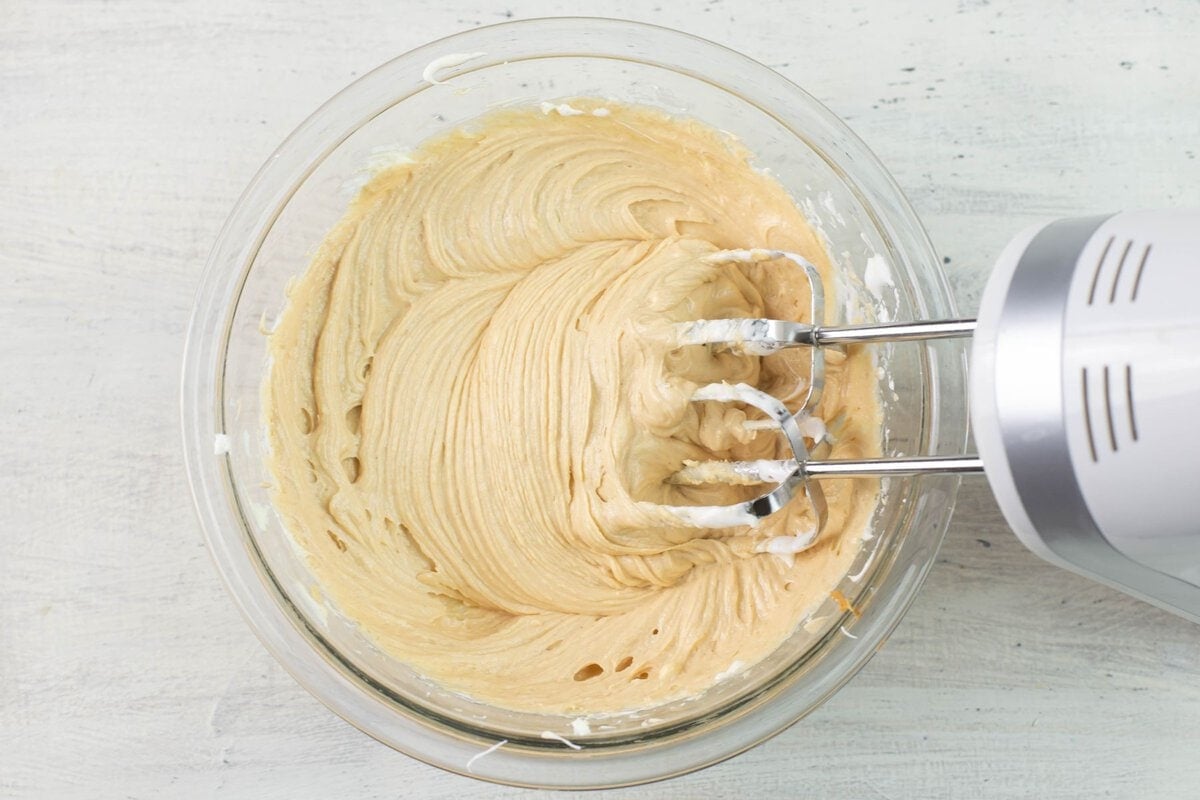 Mixing bowl with beater filled with beaten peanut butter dip.
