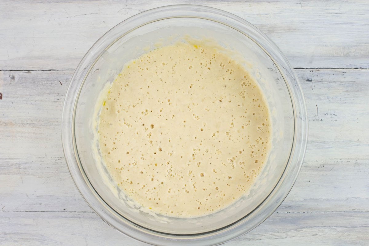 Overhead image of a bowl of bubbly sourdough sponge.