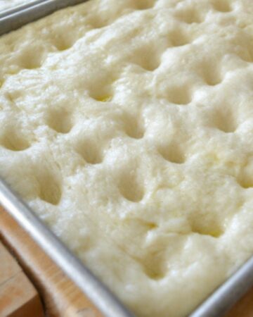Closeup of sour dough focaccia dough in the pan before baking.