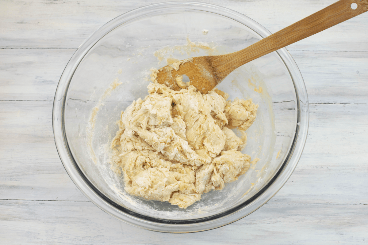 Mixing dough and flour with a spoon until it is stiff.