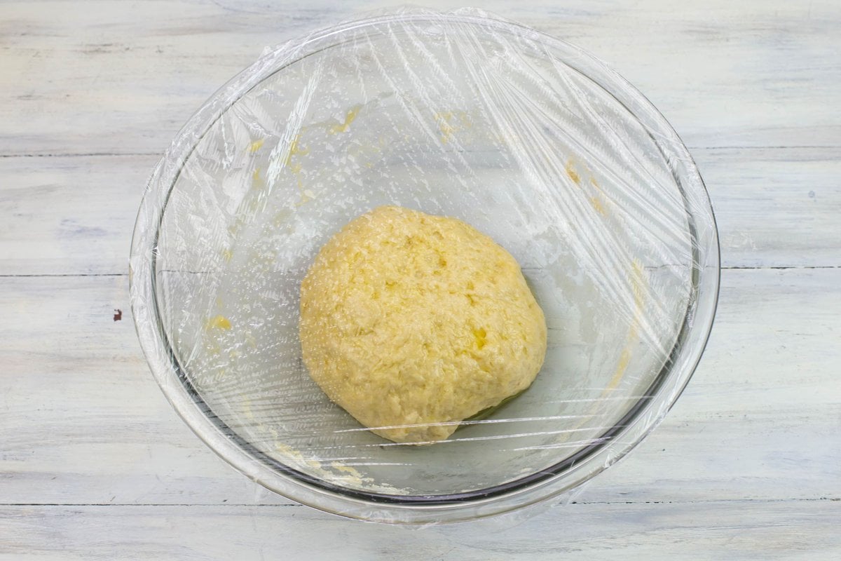 Oiled ball of dough resting in a bowl before rising.